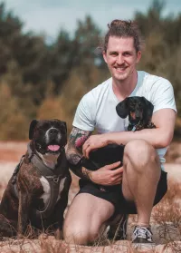 Nino Nell mit zwei Hunden auf einer Wiese